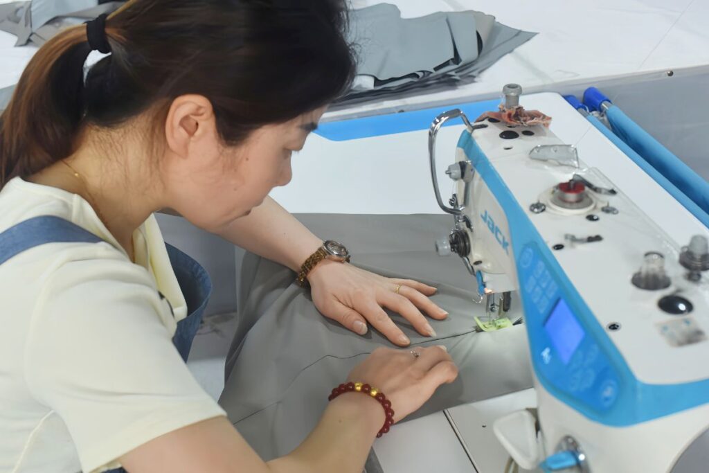 A seamstress working on one of Itorch Apparel's production line sewing machines.