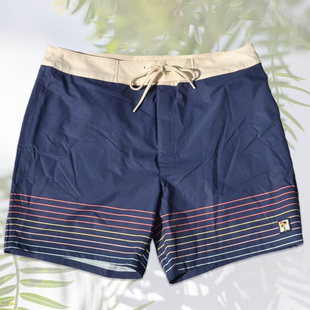 Men's boardshorts in four-way stretch navy and beige with multi-colored stripes.
