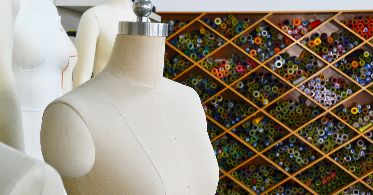 Mannequins in front of a multitude of thread roll in Itorch Apparel's sampling room.
