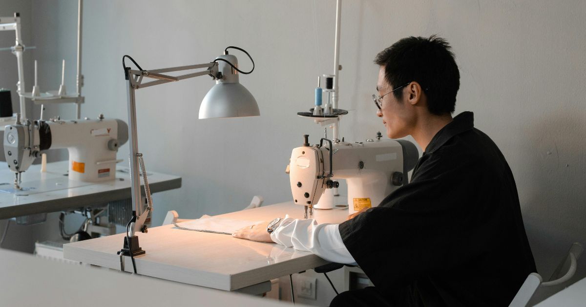 A person sewing apparel components in Itorch Apparel's factory.