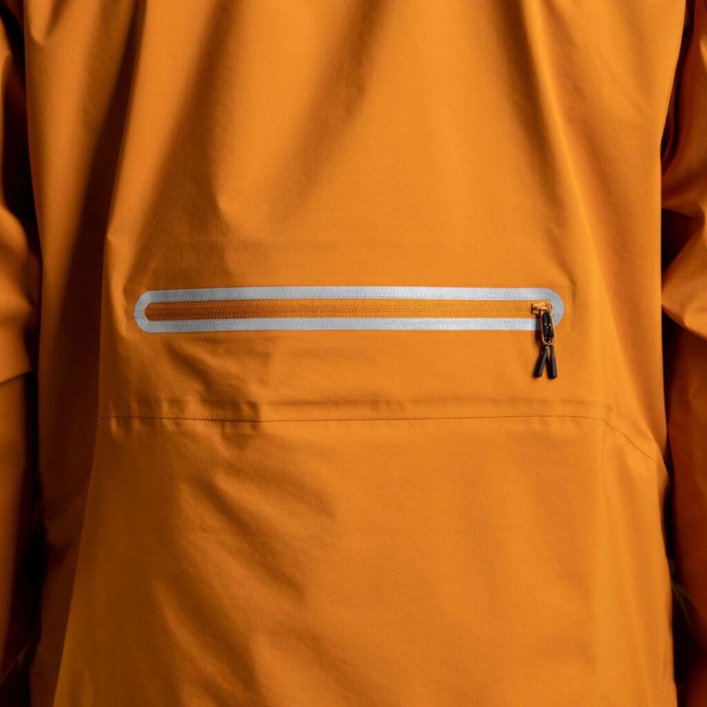 Laser-cut reflective seam surrounding a zip on a winter jacket.