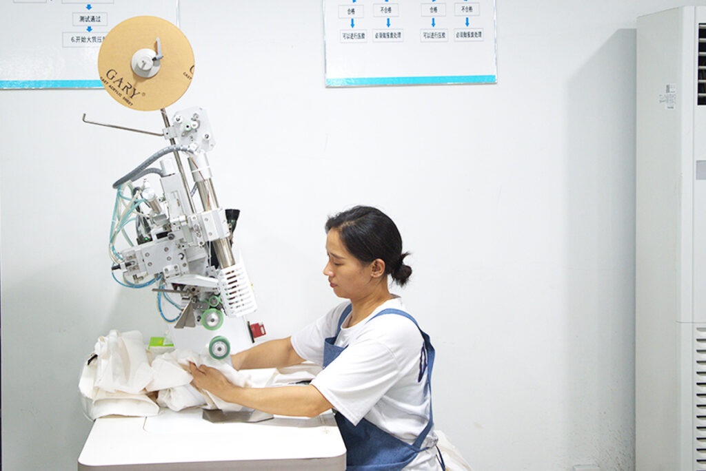 An expert operator assembling seam-sealing tape to a winter jackets inseams.